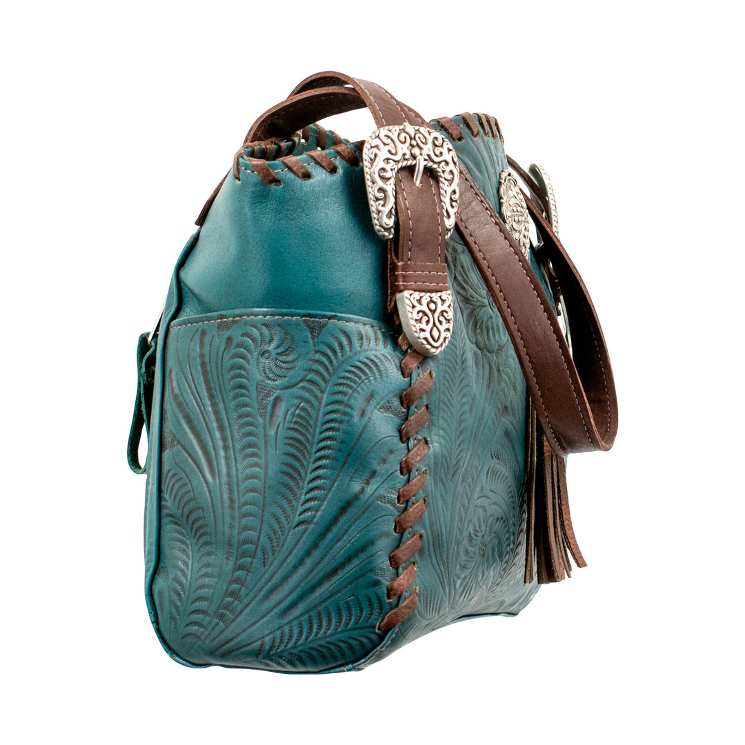 Side view of Lariats and Lace multi-compartment conceal carry tote in dark turquoise with hand tooled leather, concho and tassel accents