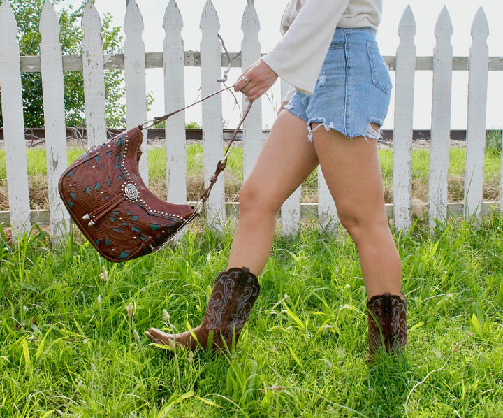 Lifestyle with model of Lady Lace hobo bag with two side pockets in medium brown with hand tooled leather and cut out accents