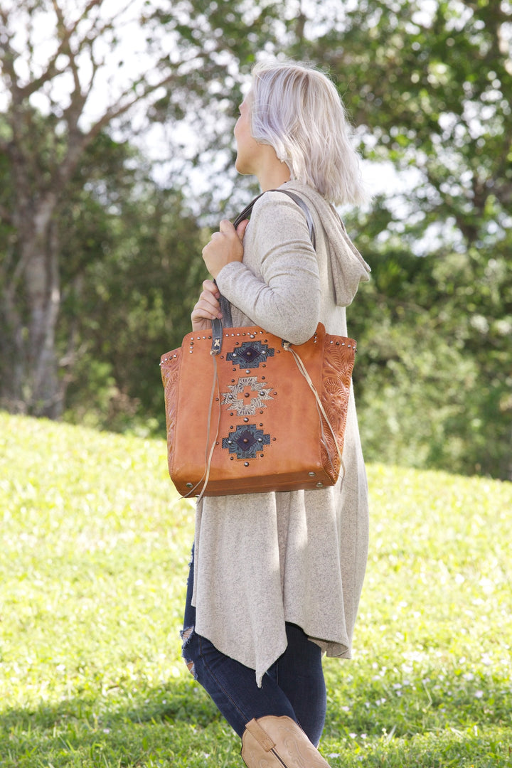 Lifestyle with model of Navajo Soul tote in natural tan with hand tooled leather accents