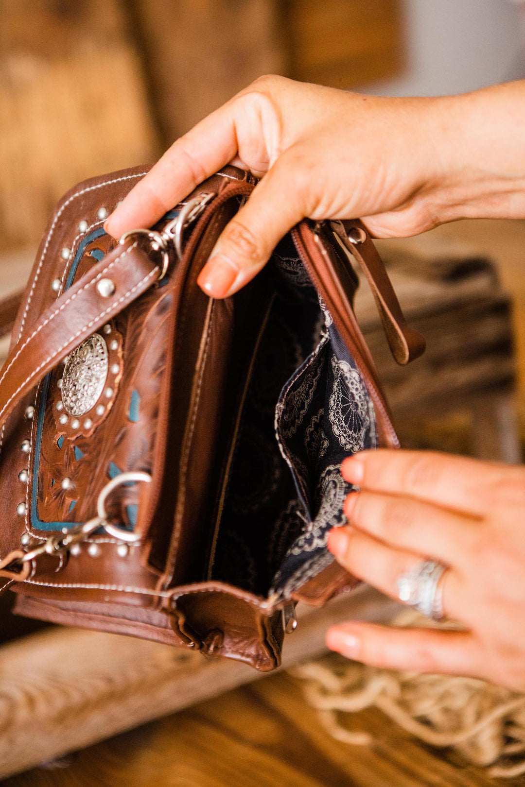 Model opening zippered compartment on Lady Lace crossbody bag