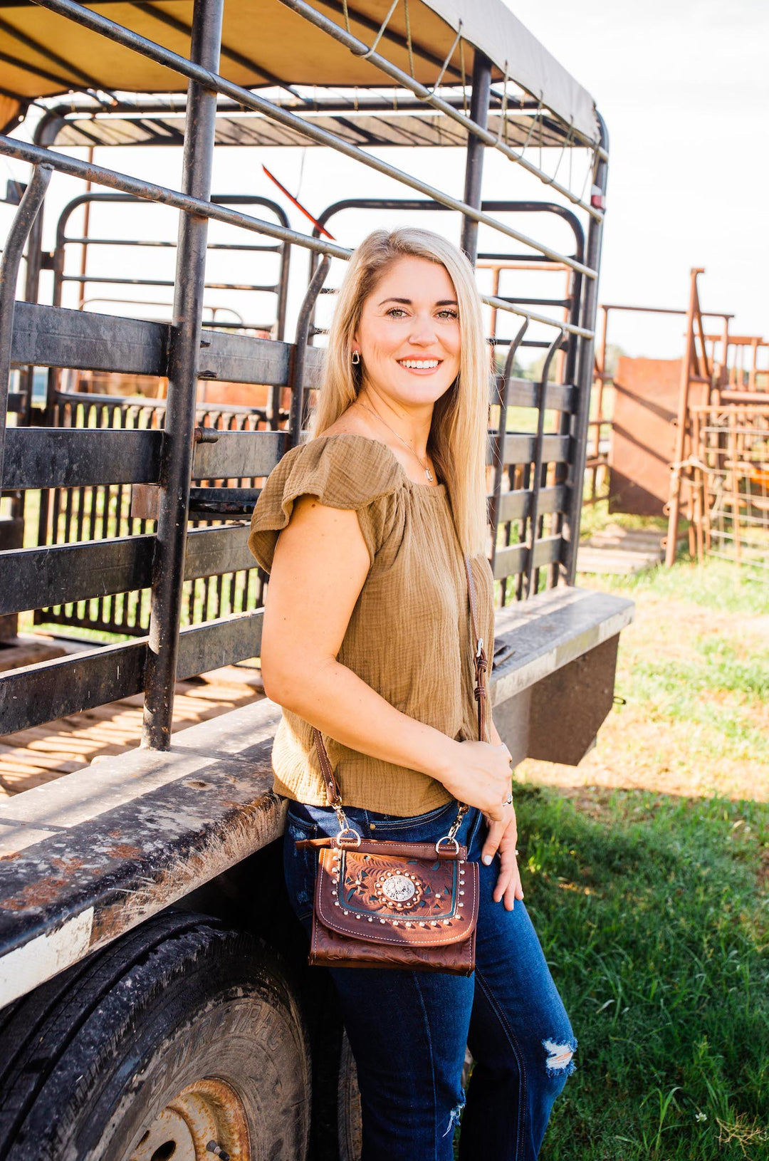 Lifestyle with model of Lady Lace crossbody bag in medium brown with hand tooled leather and cut out accents