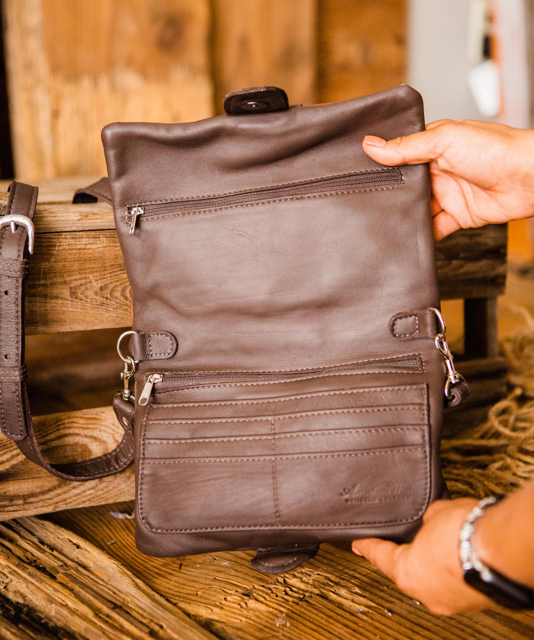 Back view of Grab and Go crossbody bag foldover wallet/crossbody bag held open by model