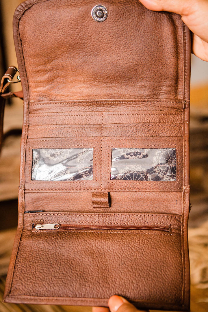 Lady Lace crossbody bag being held open by model with multiple card and slip pockets and clear id holder